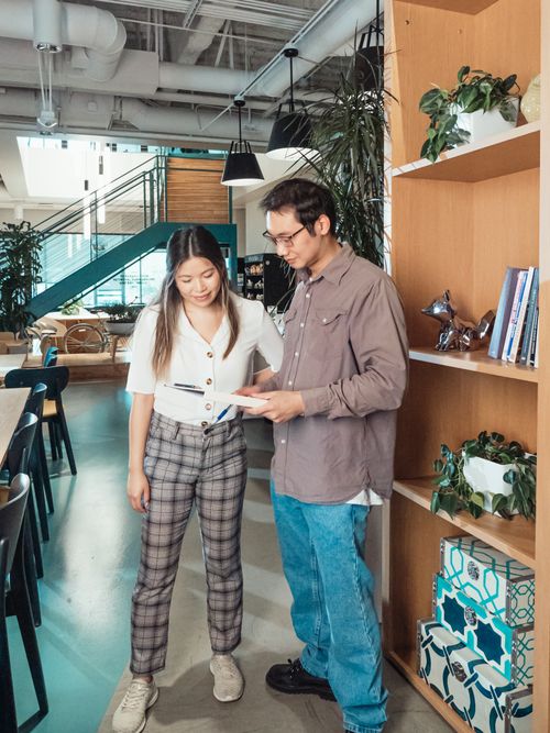 Free Two colleagues engaging in conversation in a modern office setting, focused on collaborative teamwork. Stock Photo