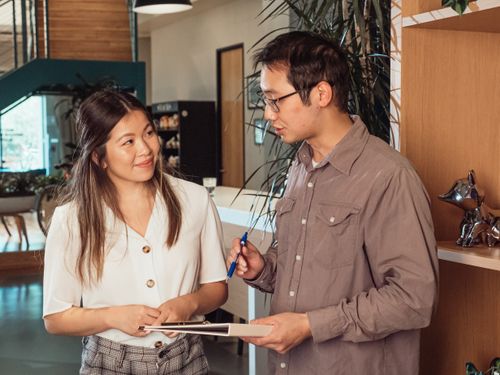 Free Team members discussing ideas in a modern office setting. Perfect for business and teamwork concepts. Stock Photo