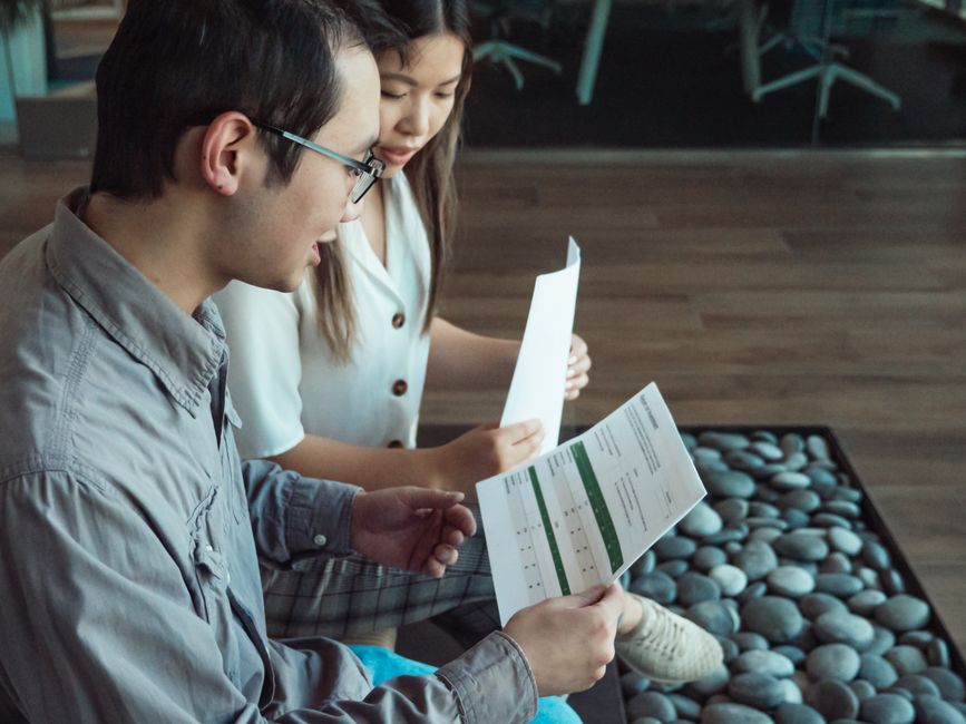 現代的なオフィス環境で書類を議論する二人の専門家。