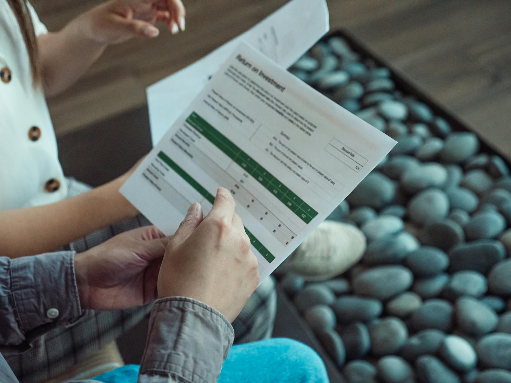 Two people discussing a financial document showing return on investment data.