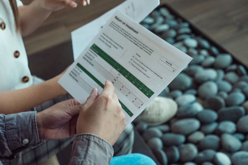 Two people discussing a financial document showing return on investment data.