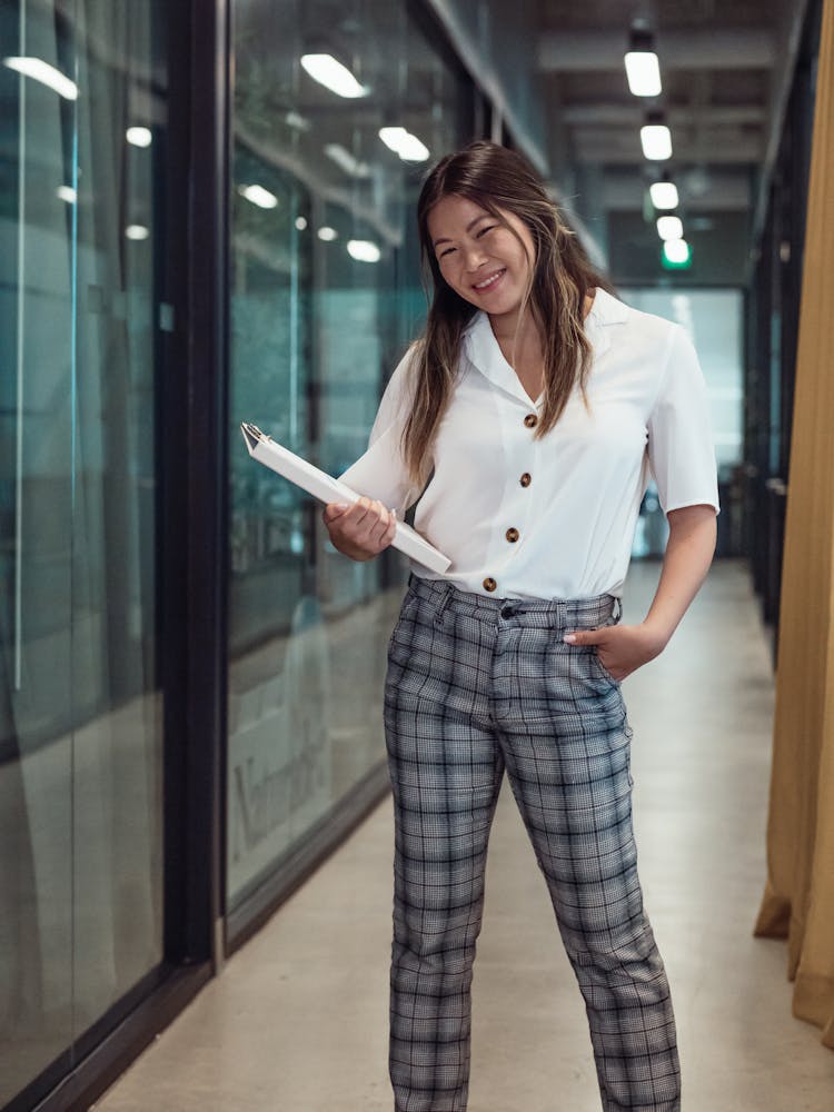 Woman Wearing Checkered Pants Holding A Binder