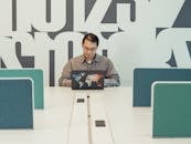 A Man in Gray Sleeves Using a Laptop