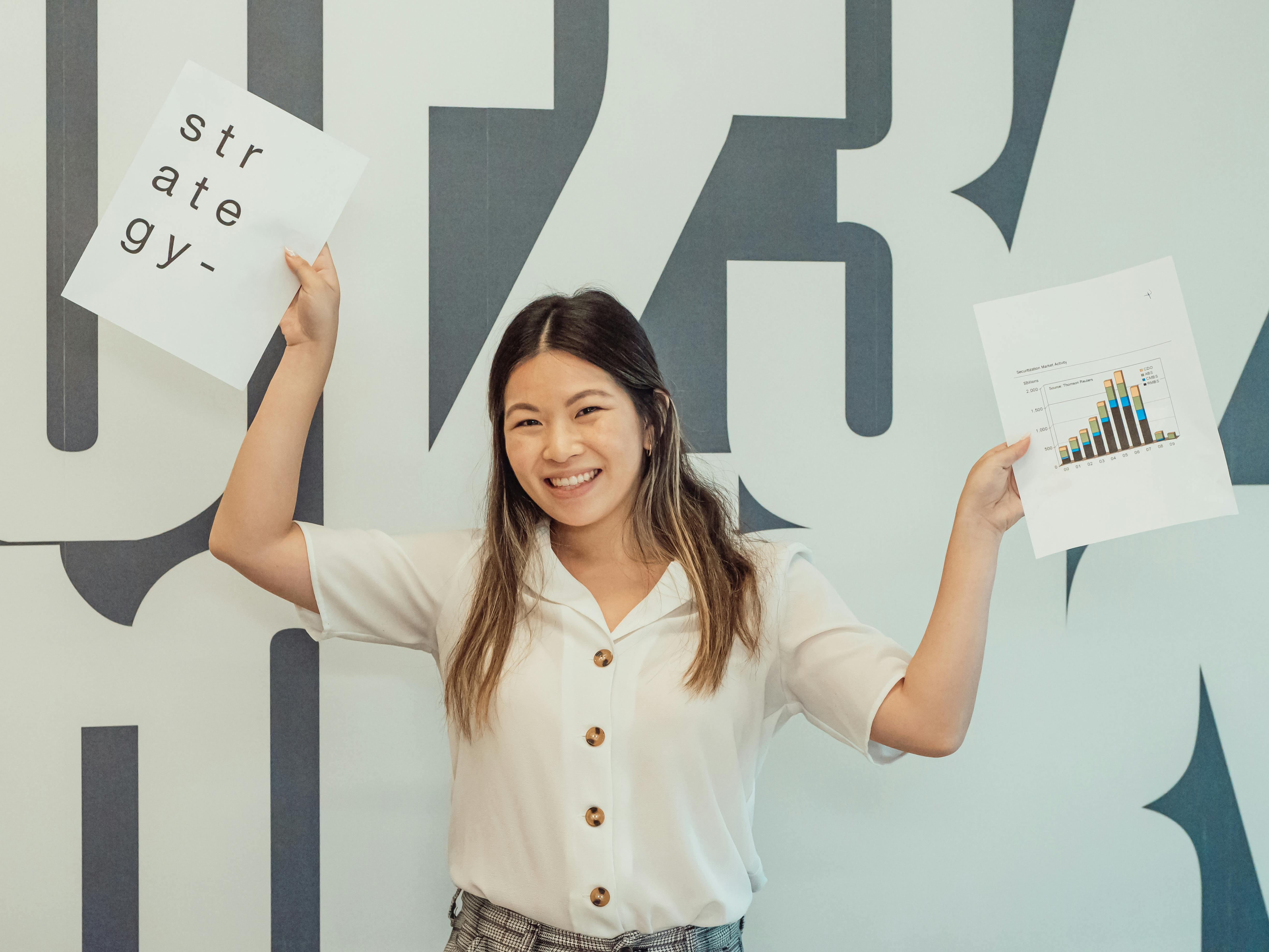 woman smiling while holding papers