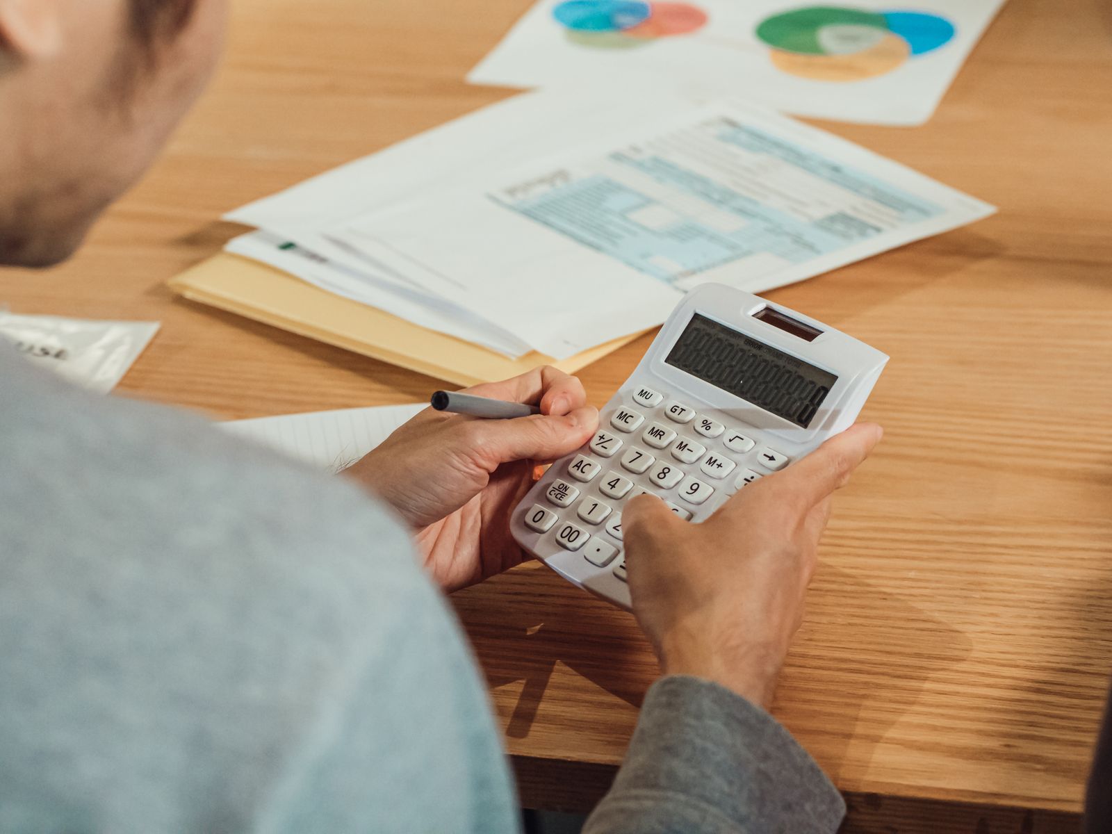 Taong gumagamit ng calculator habang sinusuri ang financial documents para sa personal loan
