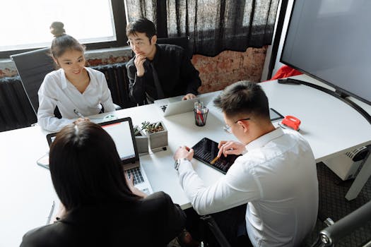 Group of diverse colleagues collaborating in a modern office environment, engaged in a meeting.
