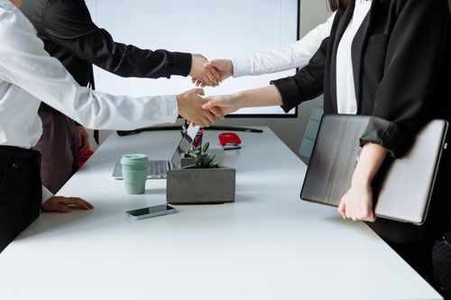 Free Professionals sealing a deal with a handshake across a conference table during a business meeting. Stock Photo