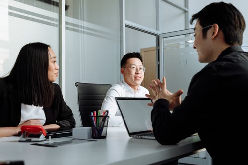 Free Business professionals engaged in a discussion at a contemporary office setting. Stock Photo