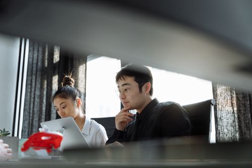 Free Two professionals working together in an office, deeply focused on their tasks. Stock Photo
