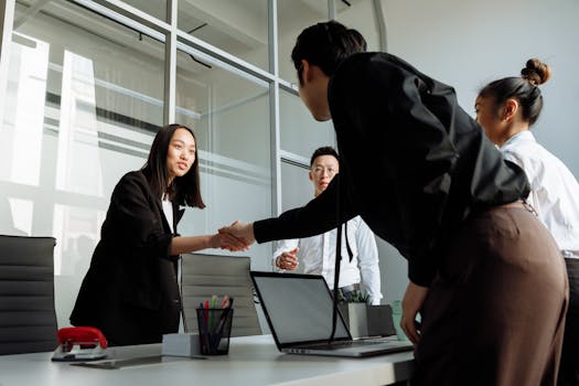 Group of business colleagues shaking hands during an office meeting.