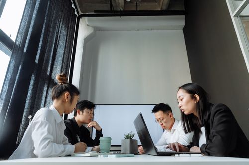 Free Diverse group of professionals in a meeting, collaborating on a project in a modern office setting. Stock Photo
