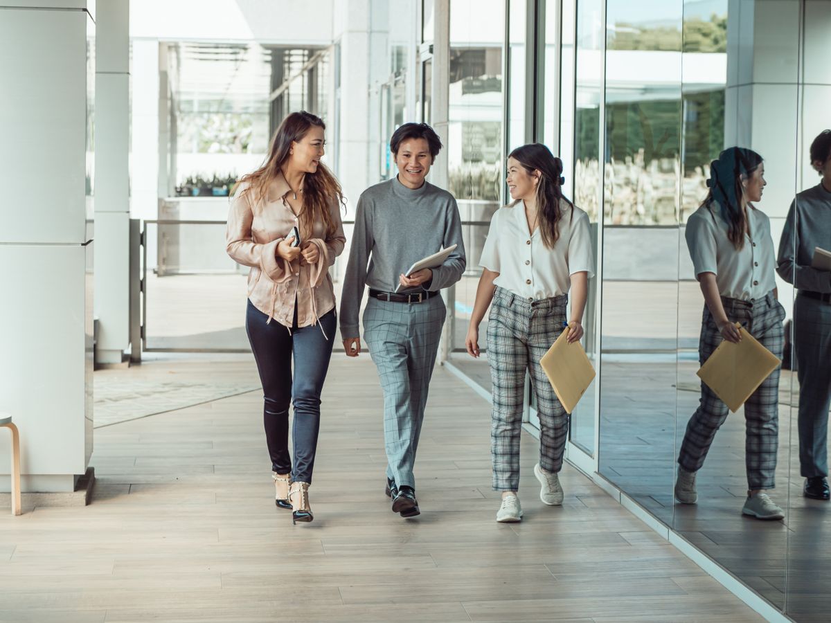 Three colleagues walking and talking together