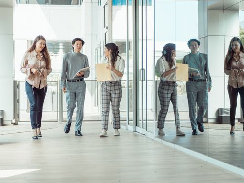 Free A group of professional colleagues walking and discussing business ideas in a modern office setting. Stock Photo