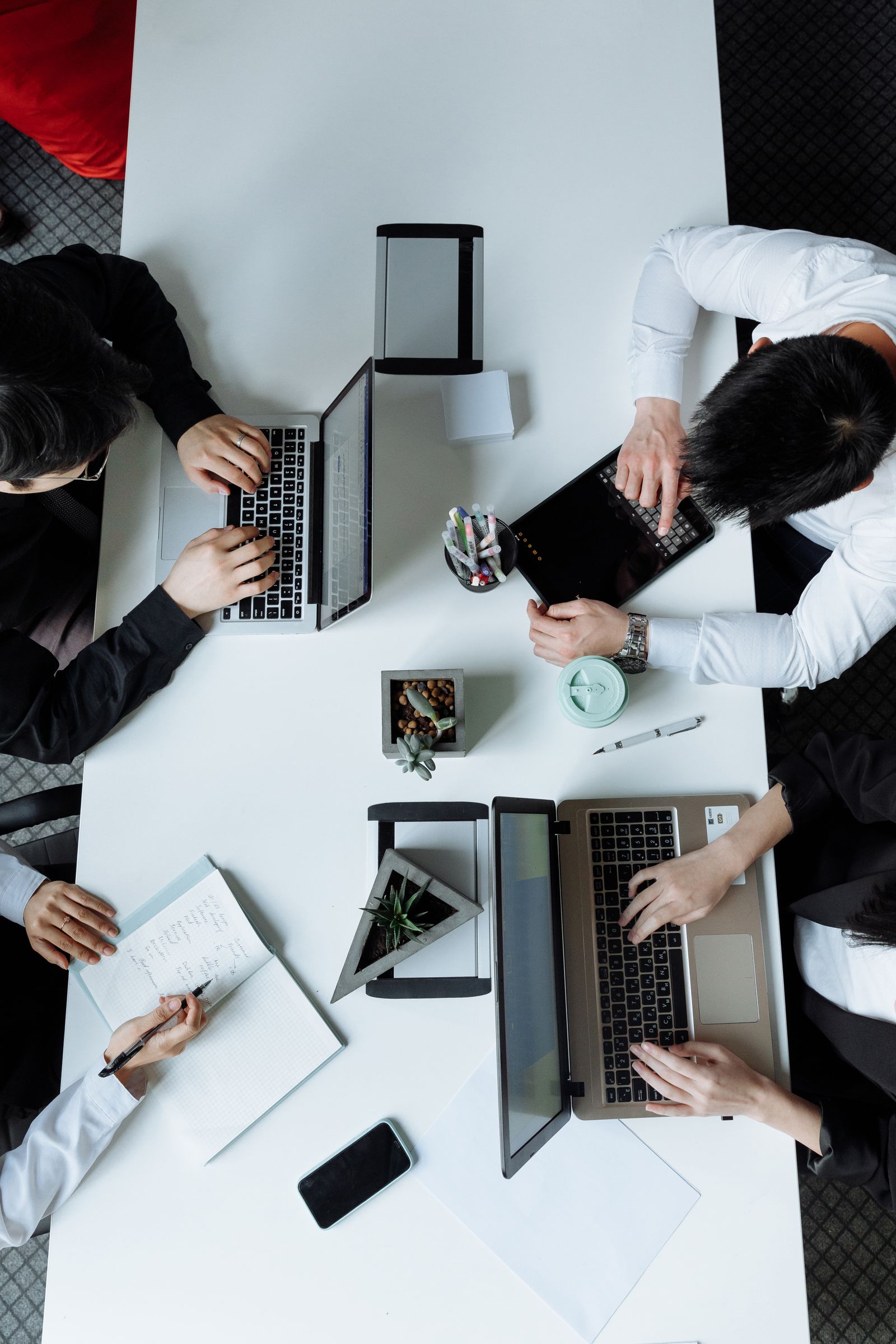 Overhead view of a team collaborating with laptops at a table