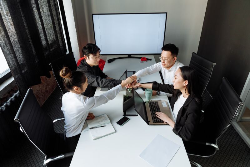 회의실에서 노트북을 놓고 협의하는 한국인 직원 네 명