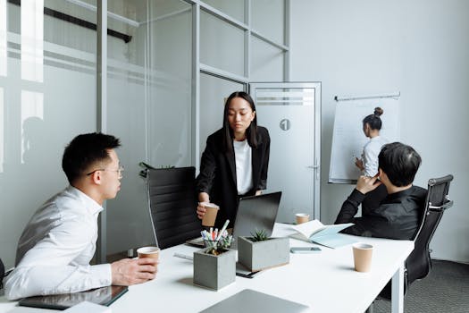 Diverse office team engaged in a collaborative meeting discussing business strategies.