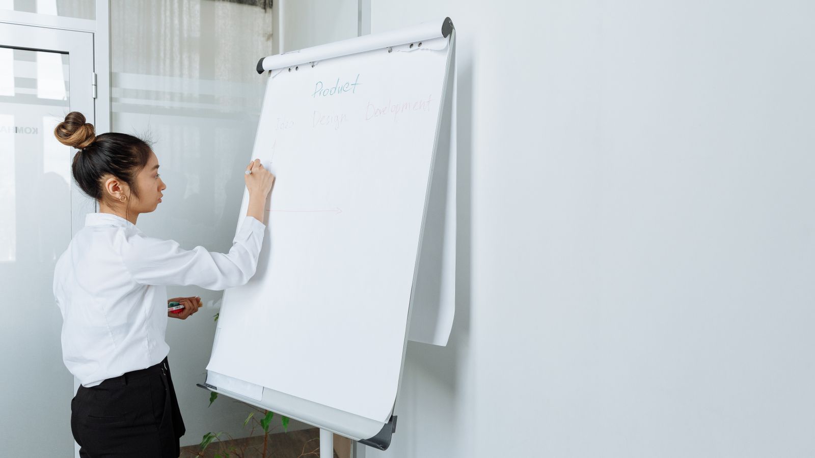 A strategist writing a validation plan on a studio canvas