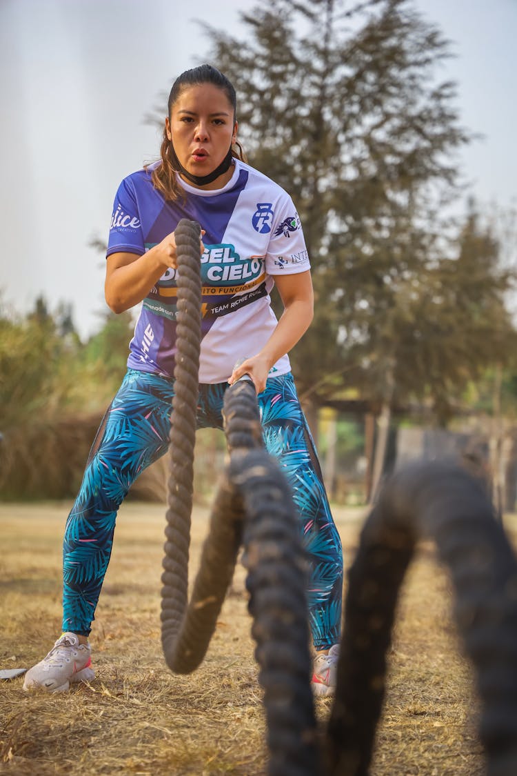 A Woman In Activewear Using Battling Ropes