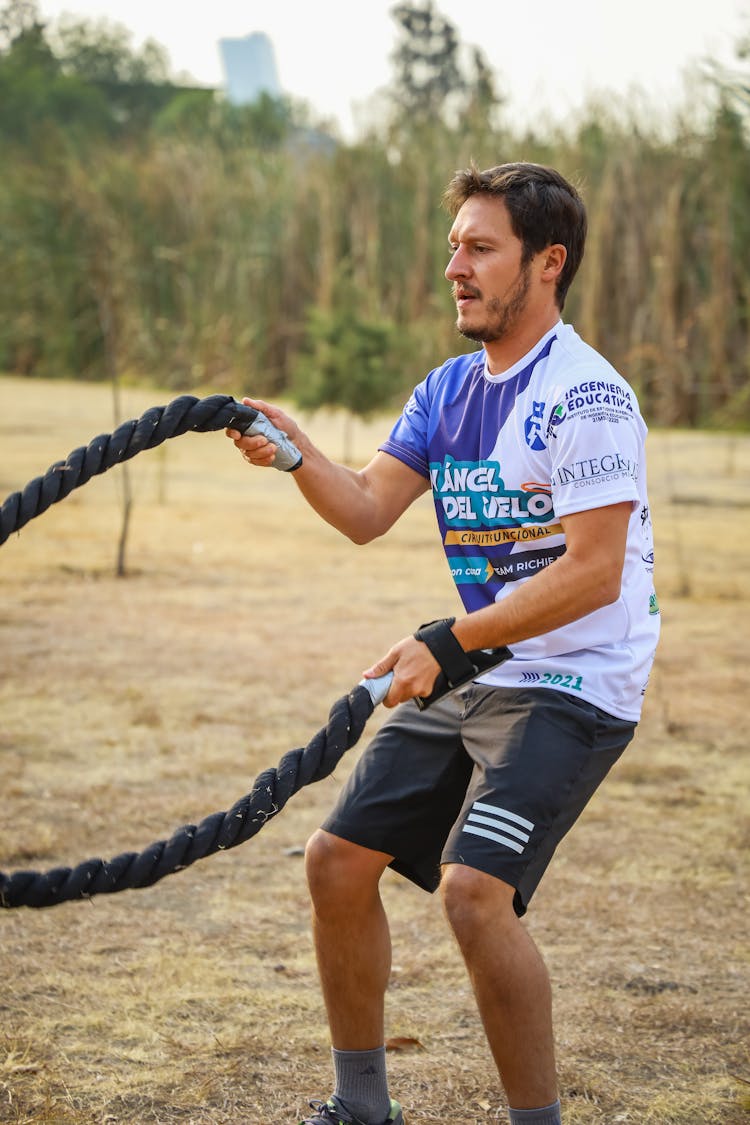 A Man In Activewear Using The Battling Ropes