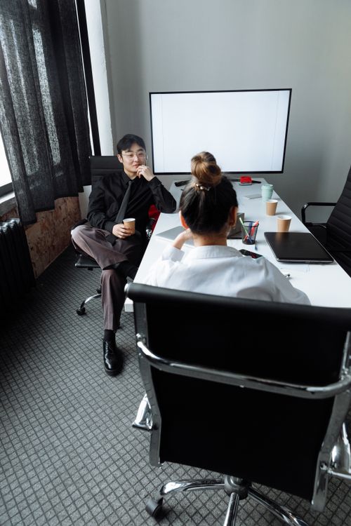 Free Professional business meeting with two people discussing ideas in a modern office. Stock Photo