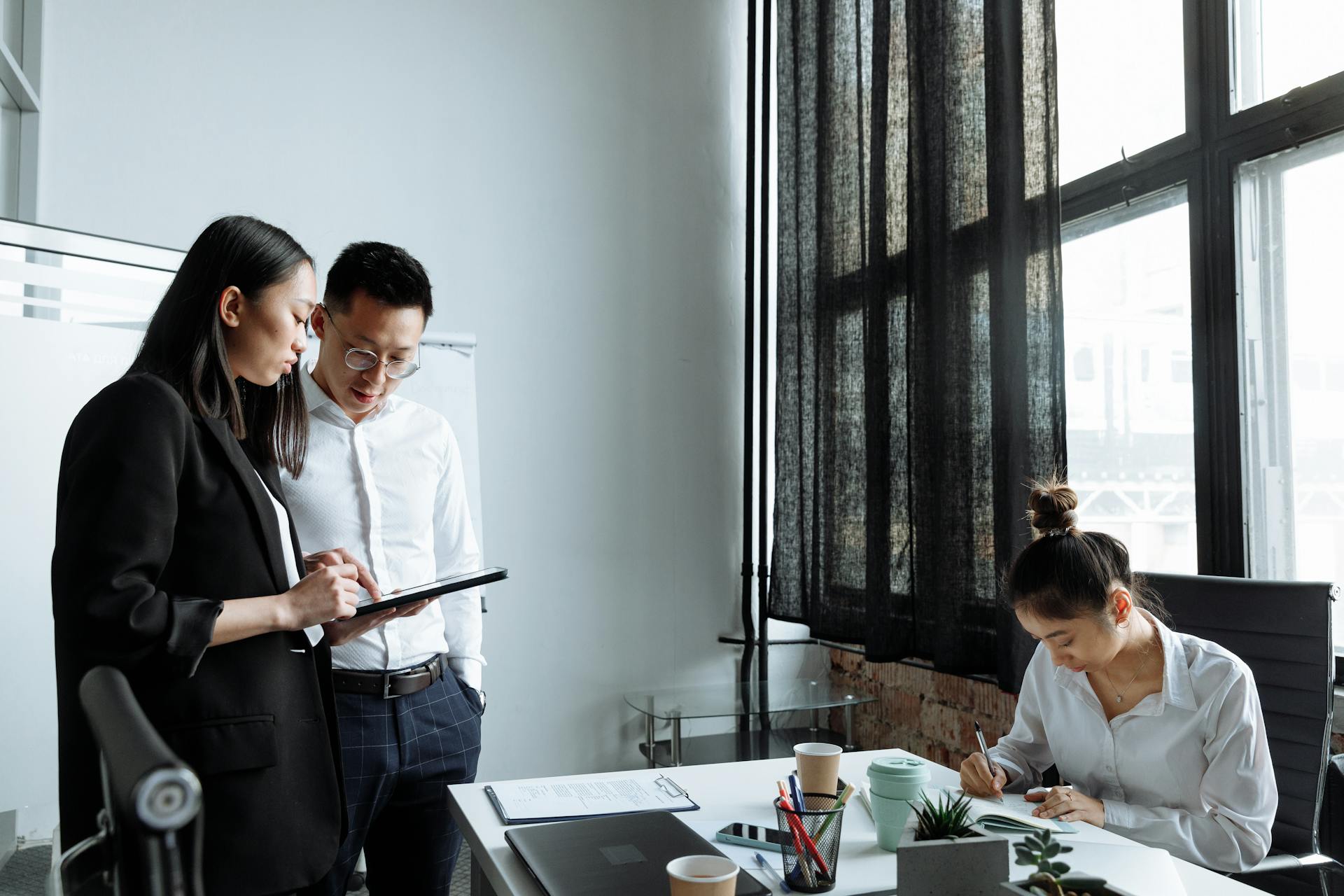 Professionals collaborating in a modern office environment, focusing on planning and teamwork.