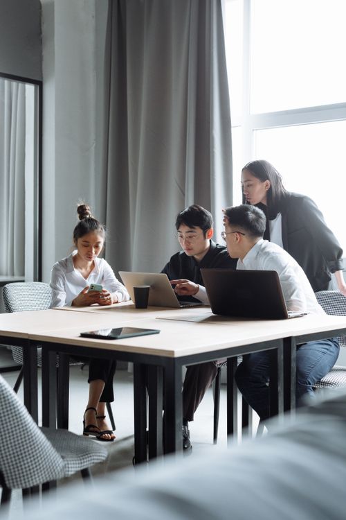 Free A group of young professionals discussing and working together in a contemporary office setting, fostering teamwork. Stock Photo