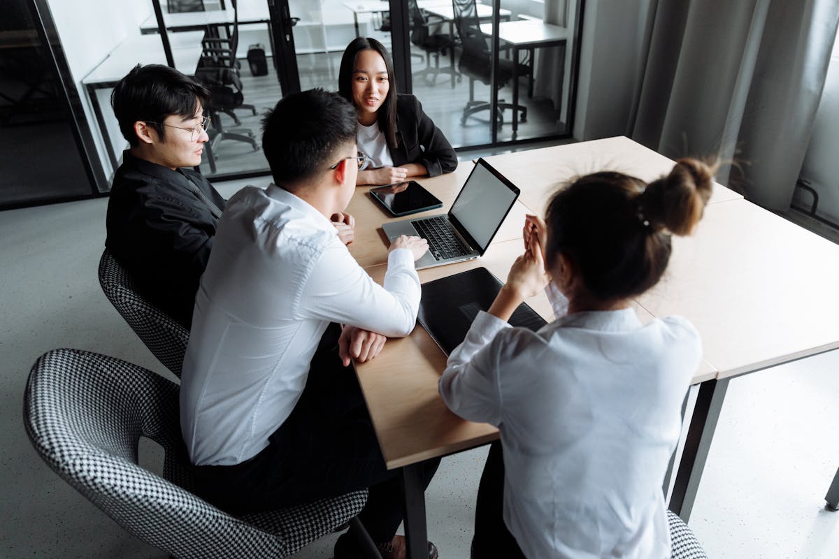 Team discussing a project around a table in a modern office.