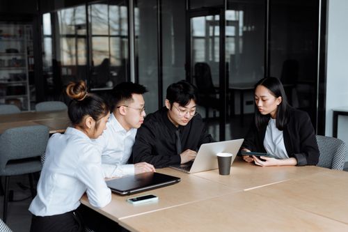 Free Group of professionals collaborating at a modern office table with laptops. Stock Photo