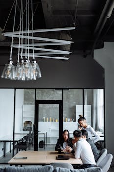 Business professionals engaged in a collaborative meeting in a stylish, modern office setting.