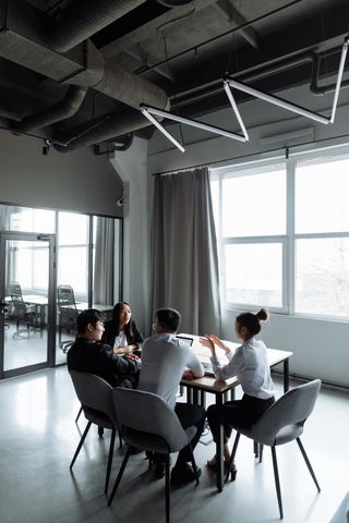 A group of professionals engaged in a business meeting inside a contemporary office setting.