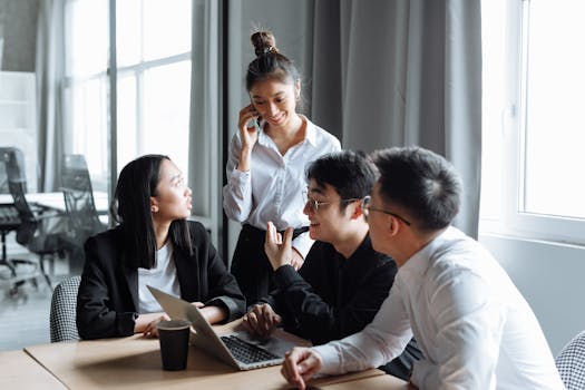 A diverse group of professionals collaborating in a modern office setting, fostering teamwork and innovation.