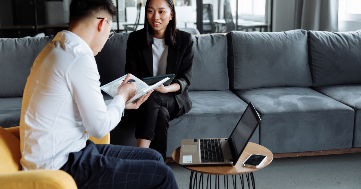 Two professionals collaborating in a modern office setting, discussing ideas with technology.