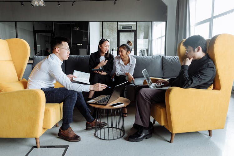 Young Professionals Having Discussion And Sitting On A Sofa