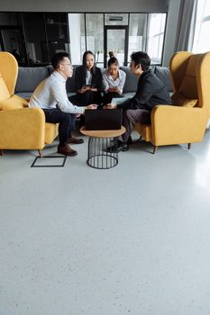 Business professionals engaged in a meeting in a contemporary office setting with a casual vibe.