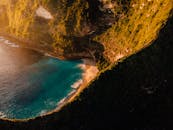 日落时分，巴厘岛的悬崖和绿松石海滩令人叹为观止的鸟瞰图，彰显了大自然的美丽