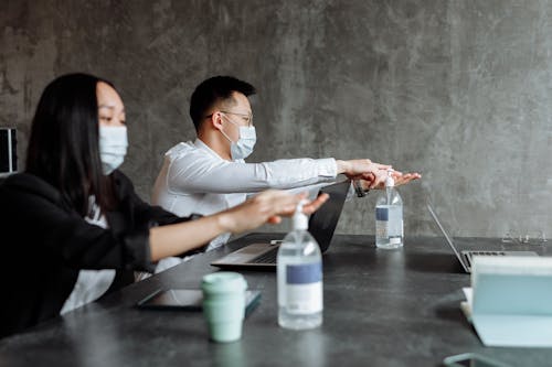 Man and Woman Using Hand Sanitizer