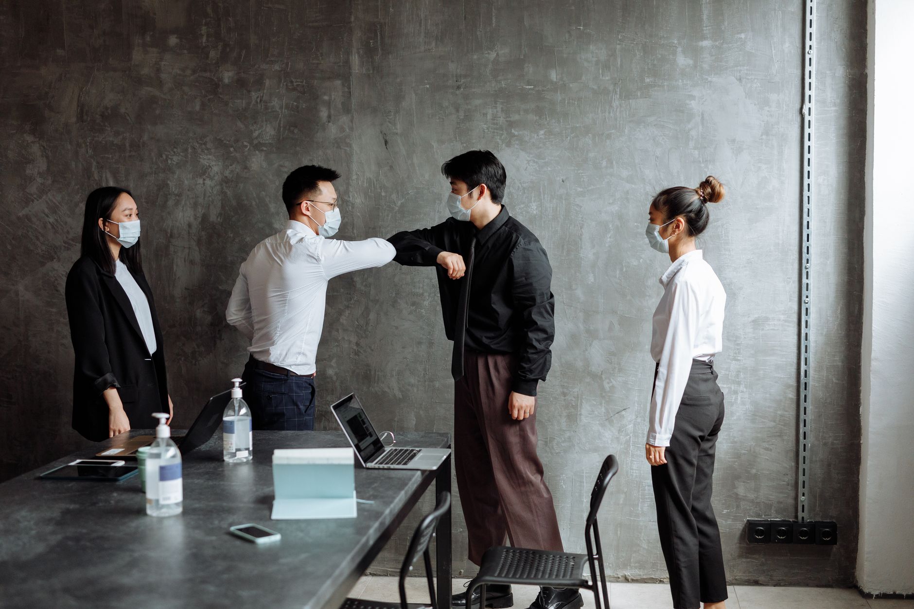 Nhân viên châu Á tự tin chào đón sếp mới trong văn phòng hiện đại.