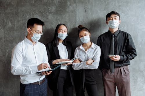 Men and Women Standing Beside Gray Wall