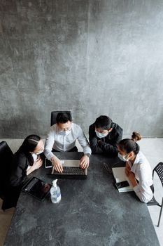 High-angle view of diverse team discussing projects during a business meeting in a modern office.