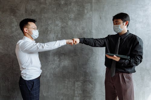 Men Wearing Face Masks Doing a Fist Bump