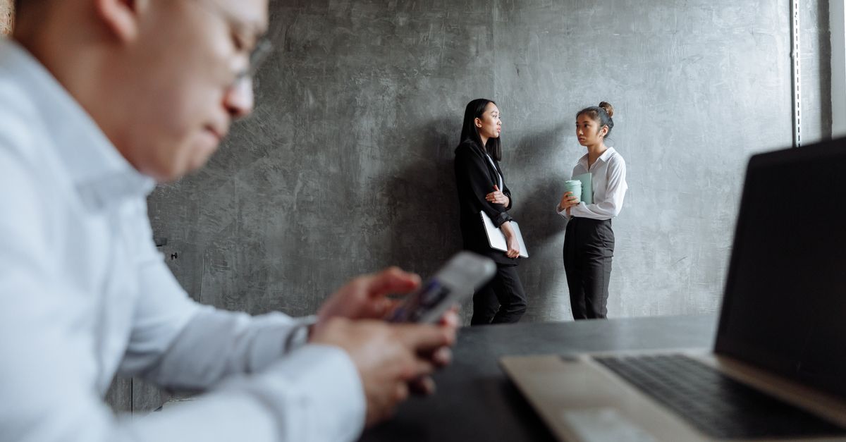 Business professionals engaged in a conversation in a contemporary office setting.