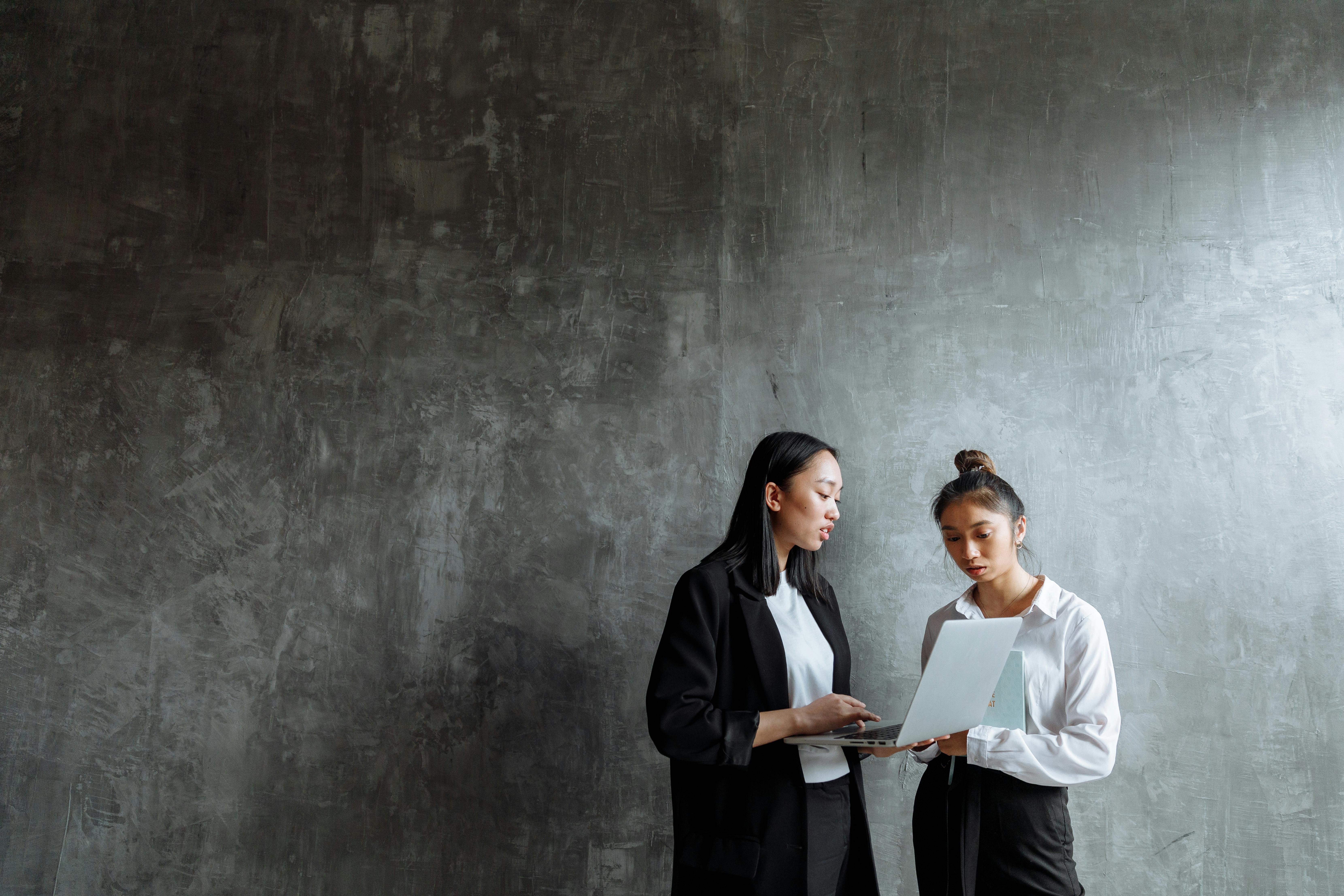 man in black coat standing beside woman in white long sleeve shirt