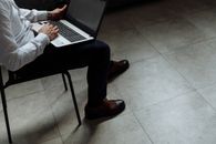 Adult working on laptop indoors, emphasizing productivity and focus.