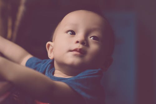 Фотография младенца, смотрящего вверх крупным планом