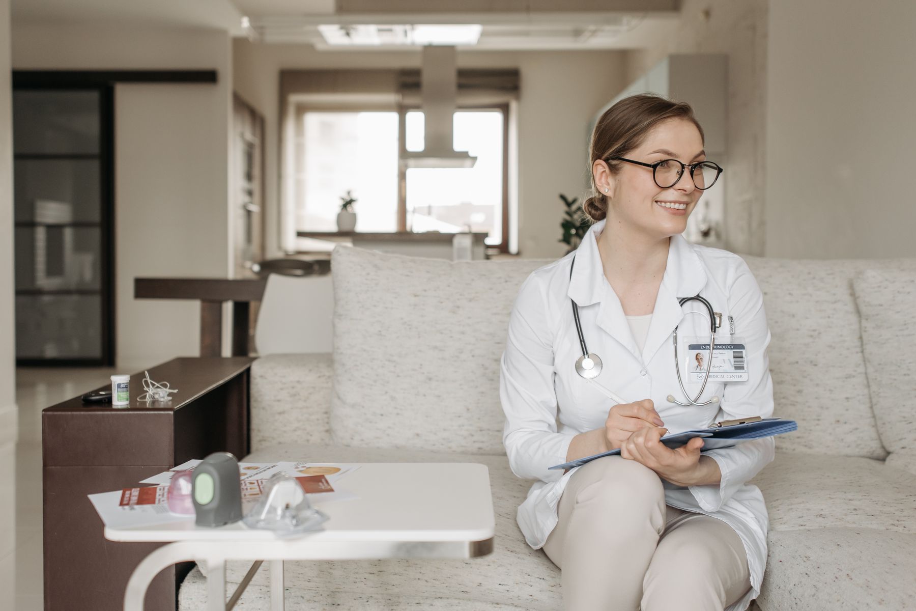 Smiling doctor seated with a clipboard in a modern office