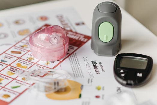 Close-up of blood sugar monitoring devices and educational materials for diabetes care.