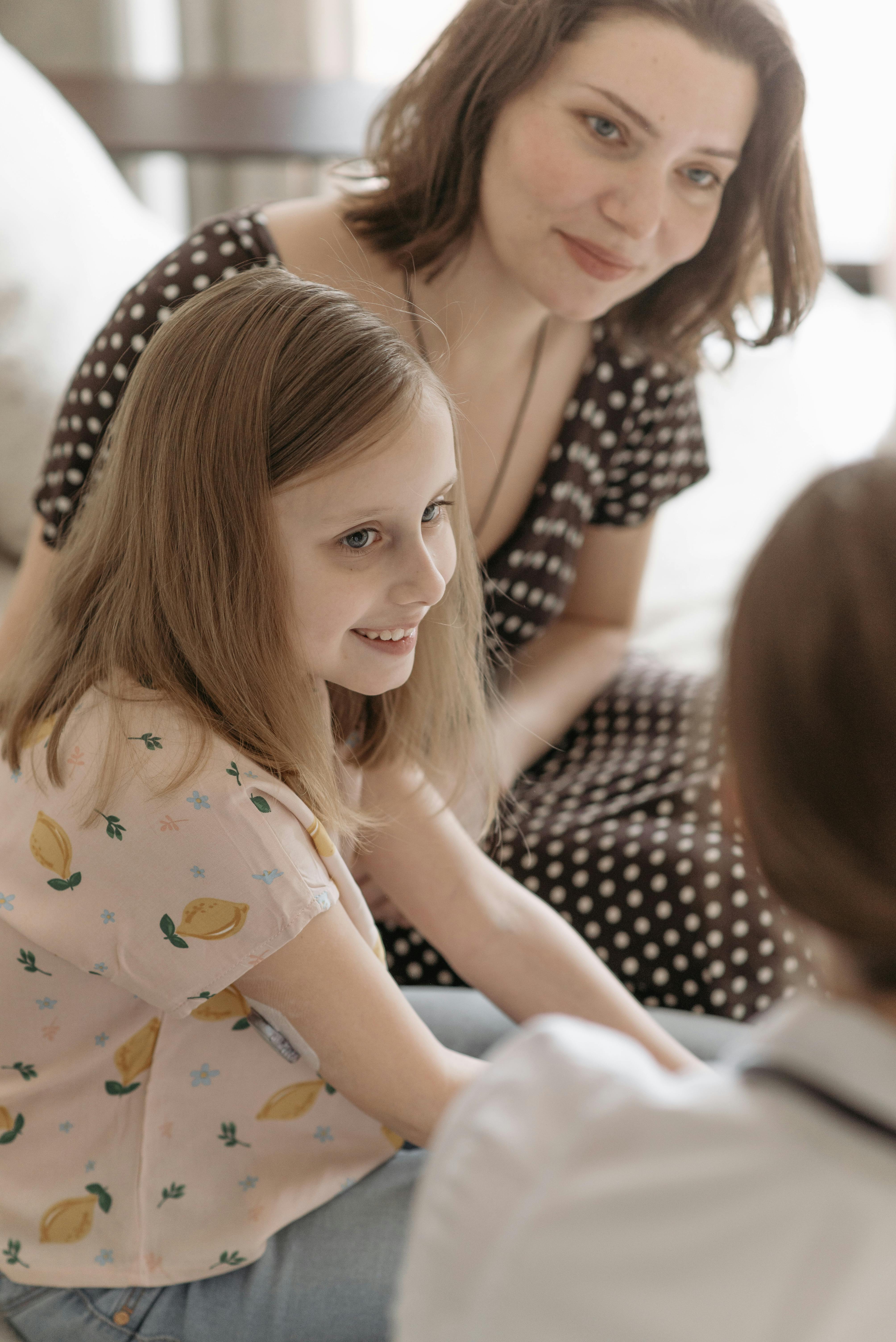 A happy mother and daughter sitting together during a consultation, smiling warmly.