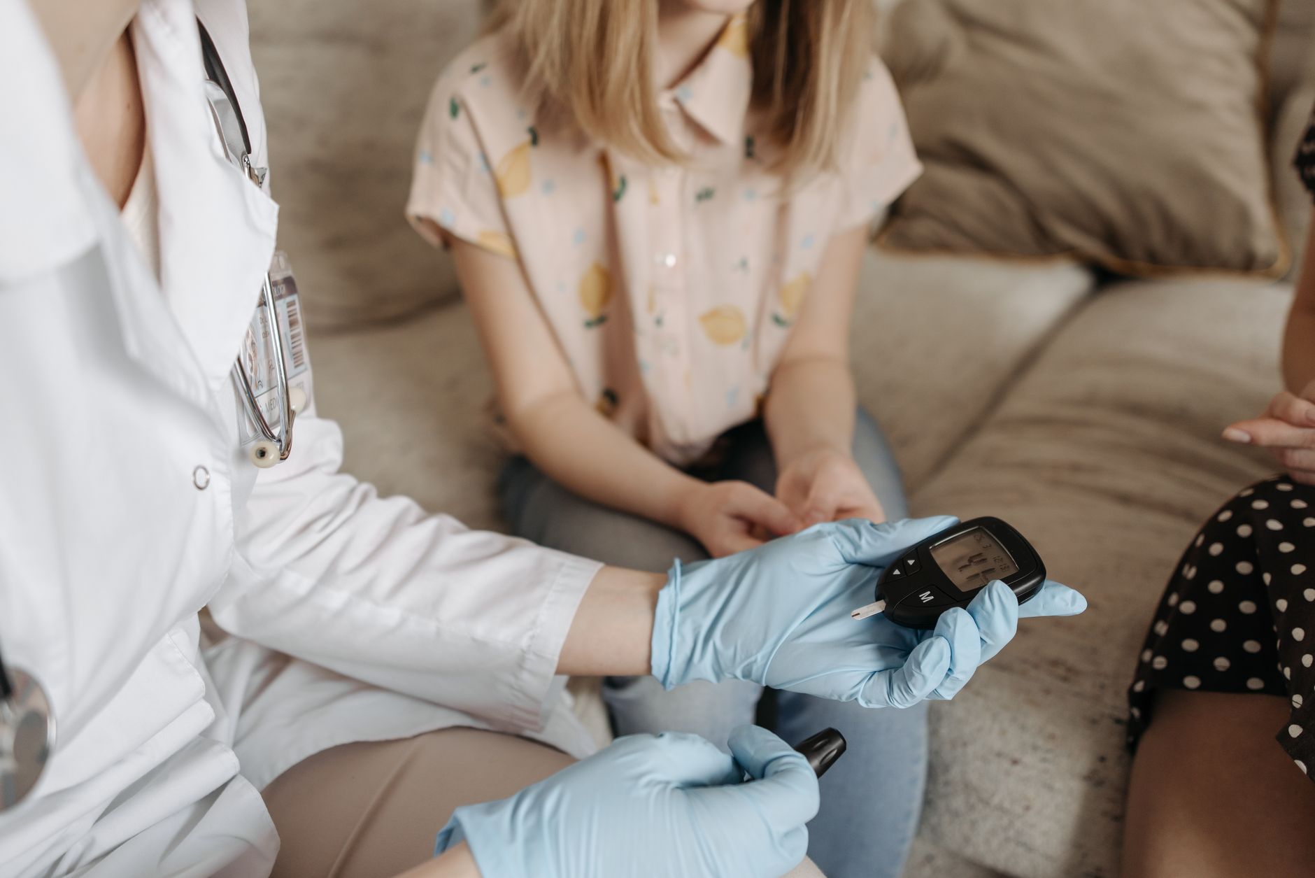 A doctor checks a glucose meter during a consultation about diabetes and metabolic health.