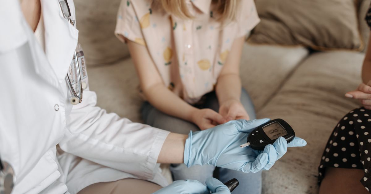 Doctor using a glucose meter to check a patient's blood sugar during a medical consultation. - Evidence evidence guide for milk thistle blood glucose meta-analysis