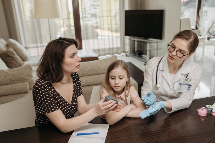 Mother And Doctor Having A Conversation While Holding Gray Device